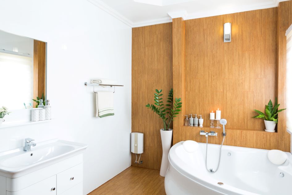 Modern bathroom with a white bathtub, wooden wall, plants, and a sleek vanity.