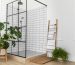 Modern bathroom with glass shower enclosure, indoor plants, and towel ladder.