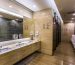 Modern public men's restroom with multiple urinals, sinks, and stalls in a clean, well-lit setting.
